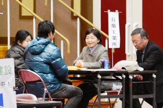 参加者と面談者がテーブルを挟んで座り、合同企業説明会の相談をしている様子の写真