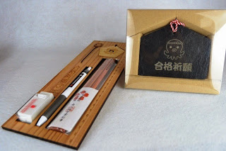 オクトパス君のイラストが描かれた合格祈願の黒い絵馬と、鉛筆や定規などの文房具が並ぶ木製の合格祈願セットの写真