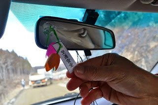 車のミラーにつけた交通安全のお守りをアップで写した写真