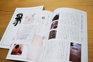 文集『彩』が開かれて机の上に置かれており、写真と一緒に文章が綴られ印刷されている写真