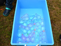 水色の箱にいれられたたくさん水風船を写した写真