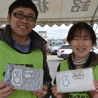 男女のスタッフが商品を手に持ち笑顔で記念撮影をしている写真