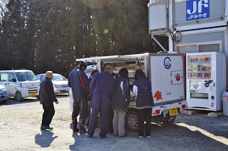 移動販売車にたくさんの人たちが商品を買いに来ている写真