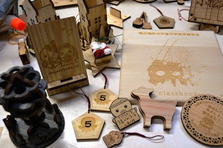 細かく加工されている木製のキーホルダーや絵馬、クラスブックなど沢山の商品が机の上に広げられている写真