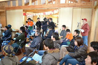 会場で行われた講座を、多くの大人や子どもが座って聞いている様子で、奥にはカメラ撮影を行うスタッフも写っている写真