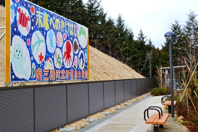 未来へのかけはしの文字が描かれた看板とベンチが並んでいる共有スペースを写した写真