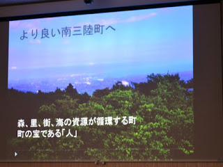 森と町が写っている写真に「より良い南三陸町へ」文字が書かれた資料がスクリーンに映し出されている写真