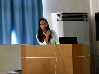 演台に立ちマイクを使いながら説明をしている亀山さんの写真