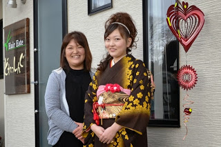 美容室の前で母親と並んで写っている振袖姿の最知 明花（さいちはるか）さんの写真