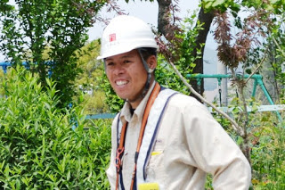 ヘルメットをかぶり作業着姿の岩淵さんを写した写真