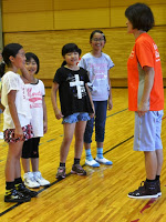 並んで立った4名の子供たちが先生の話を聞いている写真