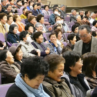 たくさんの人たちが観客席に座っている写真