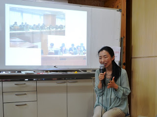 モニターの前に吉田さんが座りながらマイクを使い話をしている写真