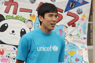 水色のユニセフのTシャツを着た長谷部選手が話をしている様子をアップで写した写真