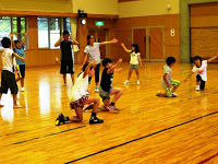 体育館で、たくさんの子供たちがダンス決めポーズをしている写真