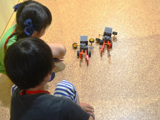 男の子と女の子が自分で作ったロボットで競争をしている写真