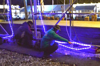 舞台のイルミネーションをしゃがみこんで確認している関係者の男性2名の写真