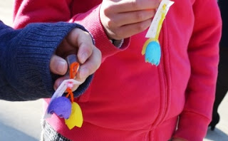 紫と黄色のマスコットと、水色と黄色のマスコットをそれぞれ持っている2人の子どもの手元のアップ写真