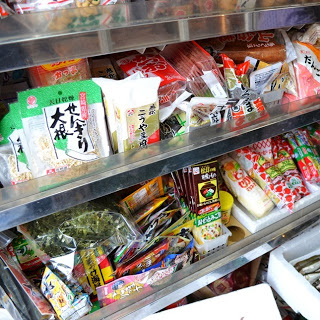 色とりどりのパッケージの調味料、乾物、魚肉ソーセージなどの食材が棚にぎっしりと並べられている様子が写っている写真