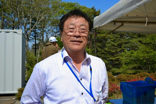 白いシャツを着てメガネをかけた遠藤さんが正面をみている写真