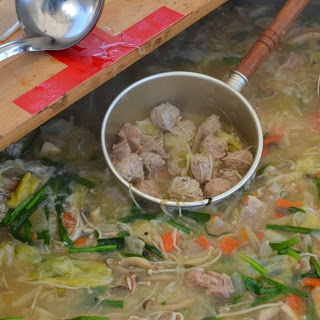 大きな鍋で汁物をついでいる写真