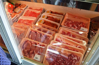 冷蔵棚の中に、発砲トレーに入った牛肉や豚肉が整然と並んでいる様子が写っている写真