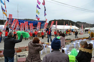 観客が緑のボンボンをふりながら応援をし、亜KIRAさんが歌を歌っている写真