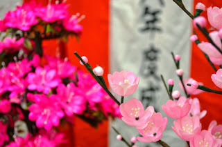 淡いピンクのシルクフラワーを接写しており、花の細部まで繊細に作られている様子がわかる写真