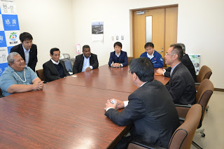 会議室の大きな長方形のテーブルを囲んで佐藤町長や役場の関係者、アダチ知事率いるパラオ共和国の方々8人の人物が座り、バイオガス事業に関する話を通訳を介して聞いている様子の写真