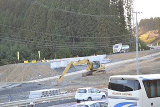 工事車両や重機が稼働している復興中の造成地を高台から撮影した写真