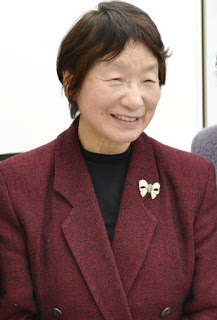 えんじ色のジャケットを着た笑顔の足立己幸（あだちみゆき）先生の写真