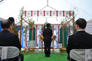 出席者が見守る中、玉串奉奠をしている佐藤南三陸町長の後ろ姿の写真
