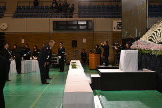 献花台から一歩下がり一礼をしている男性の写真