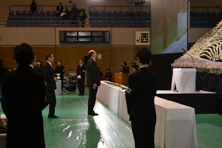 献花台の前に立ち、慰霊碑を見上げる男性の写真