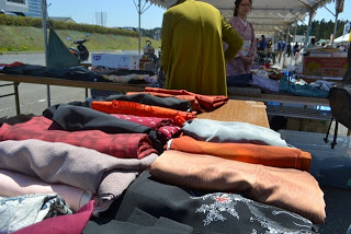 テーブルの上に広げられたさまざまな色と柄の着物の布が並んでいる様子を写した写真