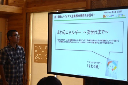 チェック柄のシャツを着た男性が「まわるエネルギー〜次世代まで〜」というテーマで、持続可能なエネルギーの重要性について伝えた発表を行っている写真