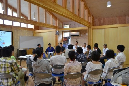 木造の温かみある会議室で丸く椅子が並べられ、多くの若者や地域の人々が参加して意見交換を行っている、南三陸町のバイオマス事業に関するグループディスカッションの写真