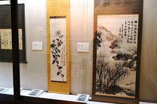 ガラスケースに展示された3点の掛け軸を写した写真