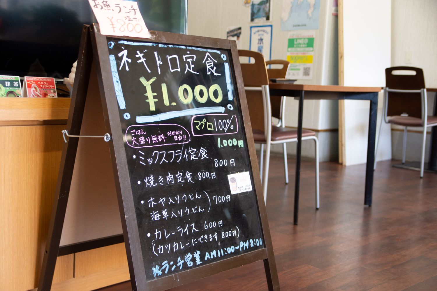 ランチメニューが書かれたブラックボードが店内に設置されたカフェスペースの写真