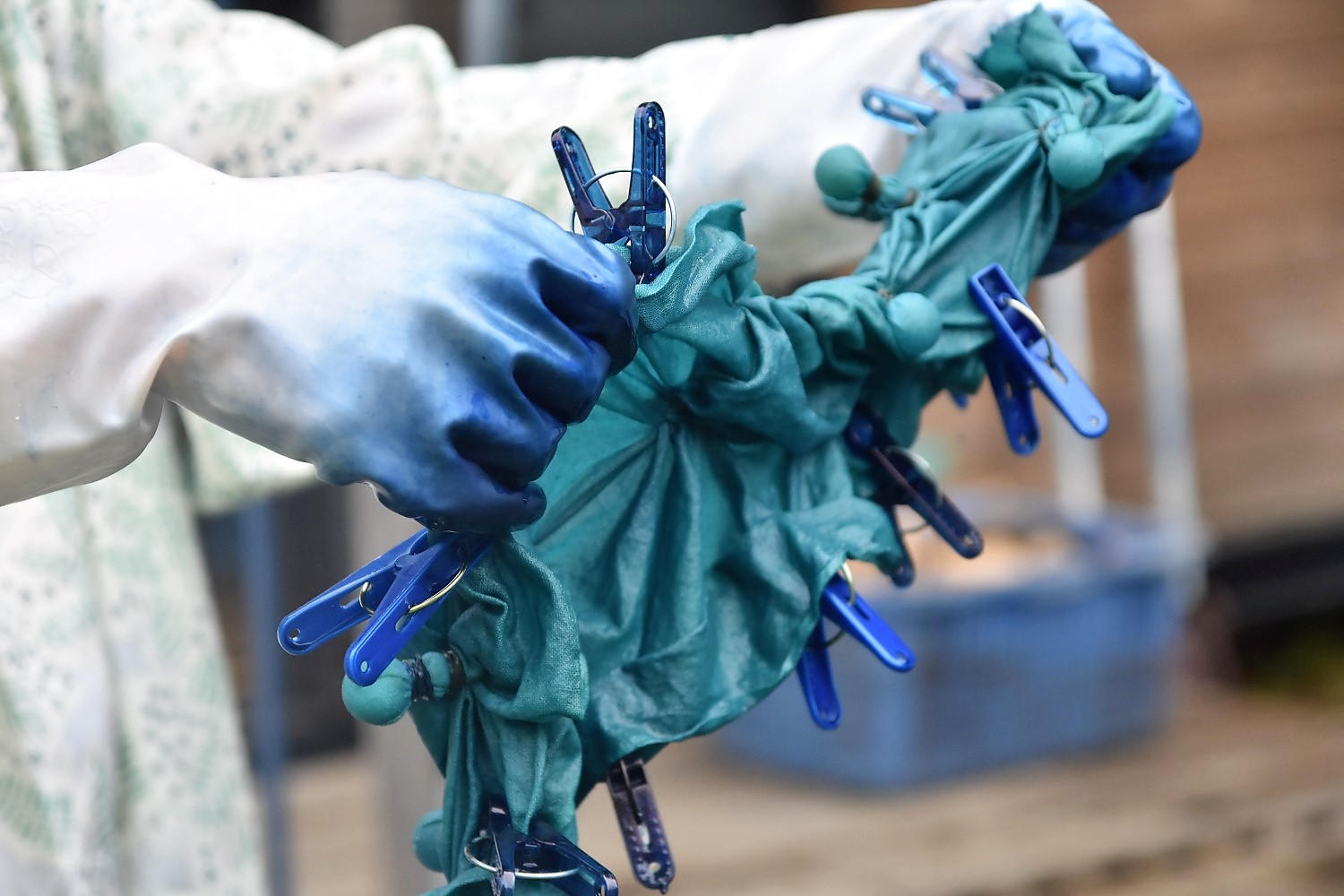 納戸色に染まった洗濯ばさみとゴムで結んだたくさんの白い玉を作った手ぬぐいを寸胴鍋からだしている写真