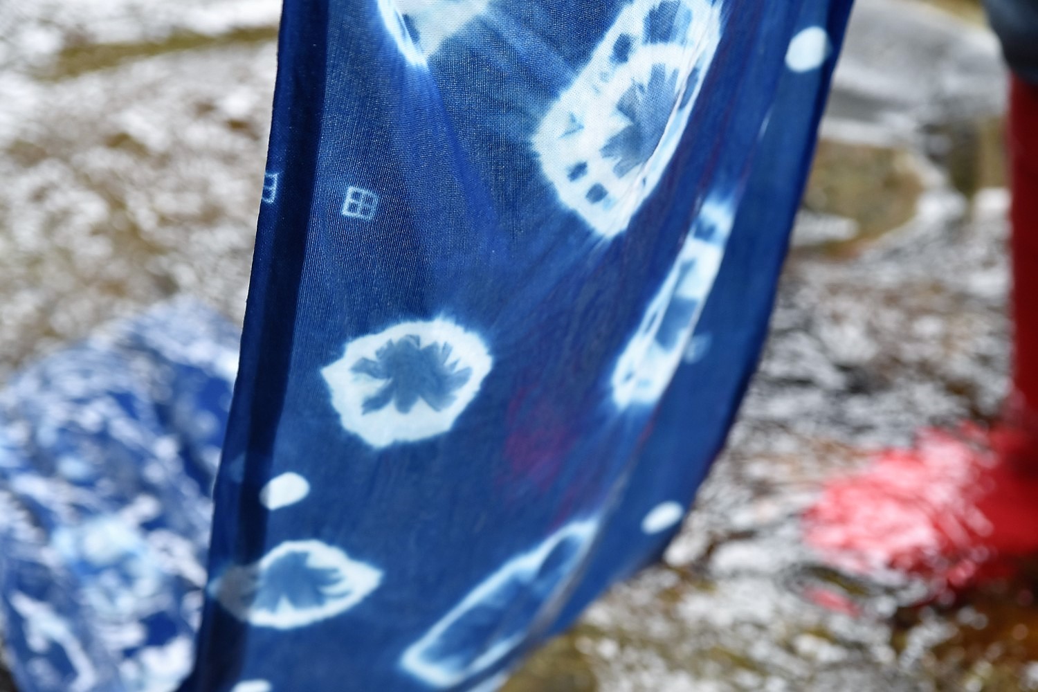 深い藍色に染まり白い模様が浮かび上がった絞り染めの藍染め布の写真