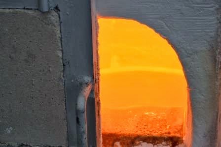 半分ほど開けた炉の扉の奥の内部が明るいオレンジ色に輝き、高温であることが分かる開口部から加熱された空間が見える写真