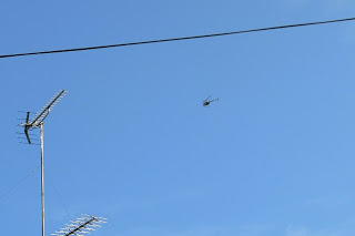 澄んだ青空の中をヘリコプターが飛行している写真