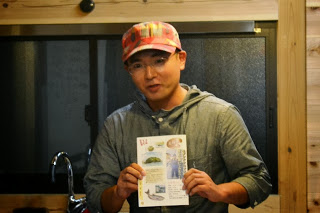 冊子をもって話をしている阿部仁文部長の写真