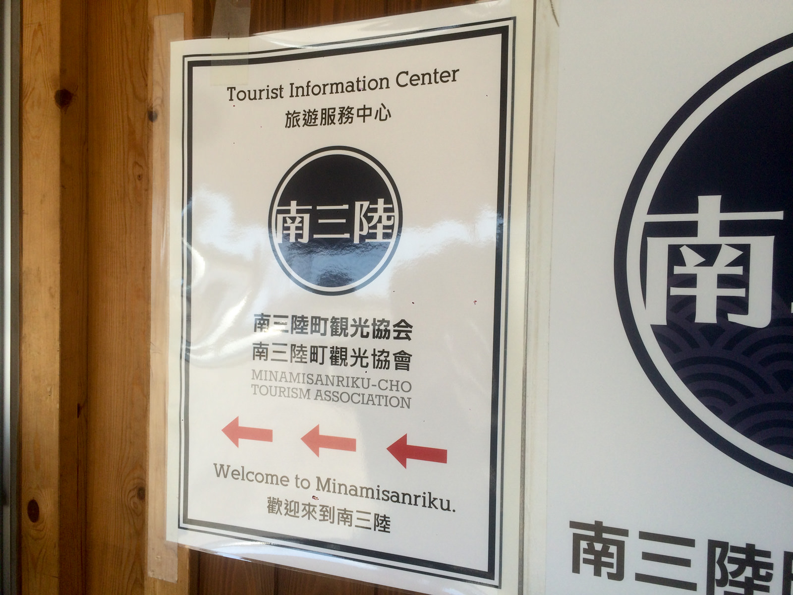 壁に掲示された、英語、中国語が併記された南三陸町観光協会の案内の写真