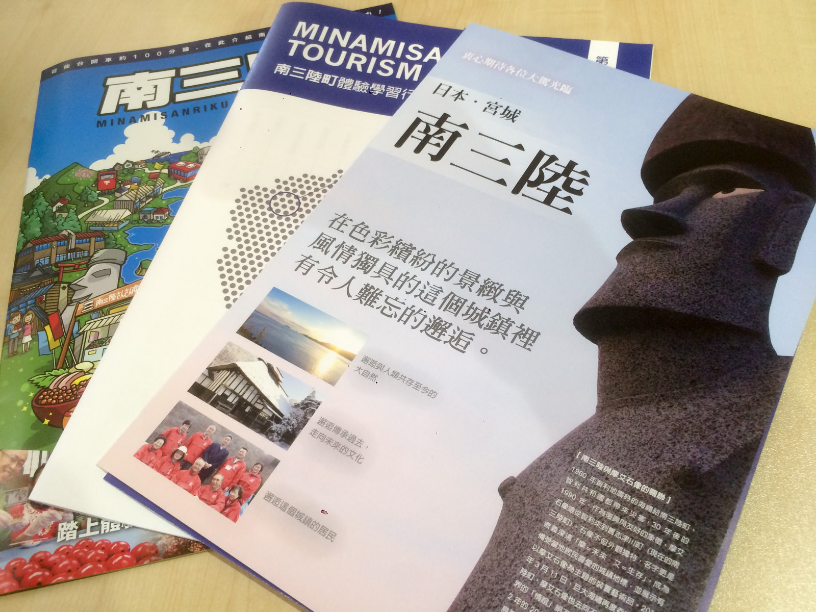 中国語などで書かれた南三陸町のパンフレットが3種類、重なって並んでいる写真