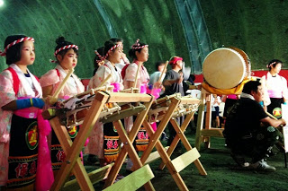 和太鼓の前で、ピンク色の衣装を着た女の子たちが並び、演奏を行っている様子が写っている写真