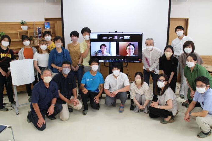 参加者と中央のモニターにはオンライン参加者2名の顔が映っており、南三陸町創業支援プログラムGAUDIEの発表会後に記念撮影をしている様子の写真