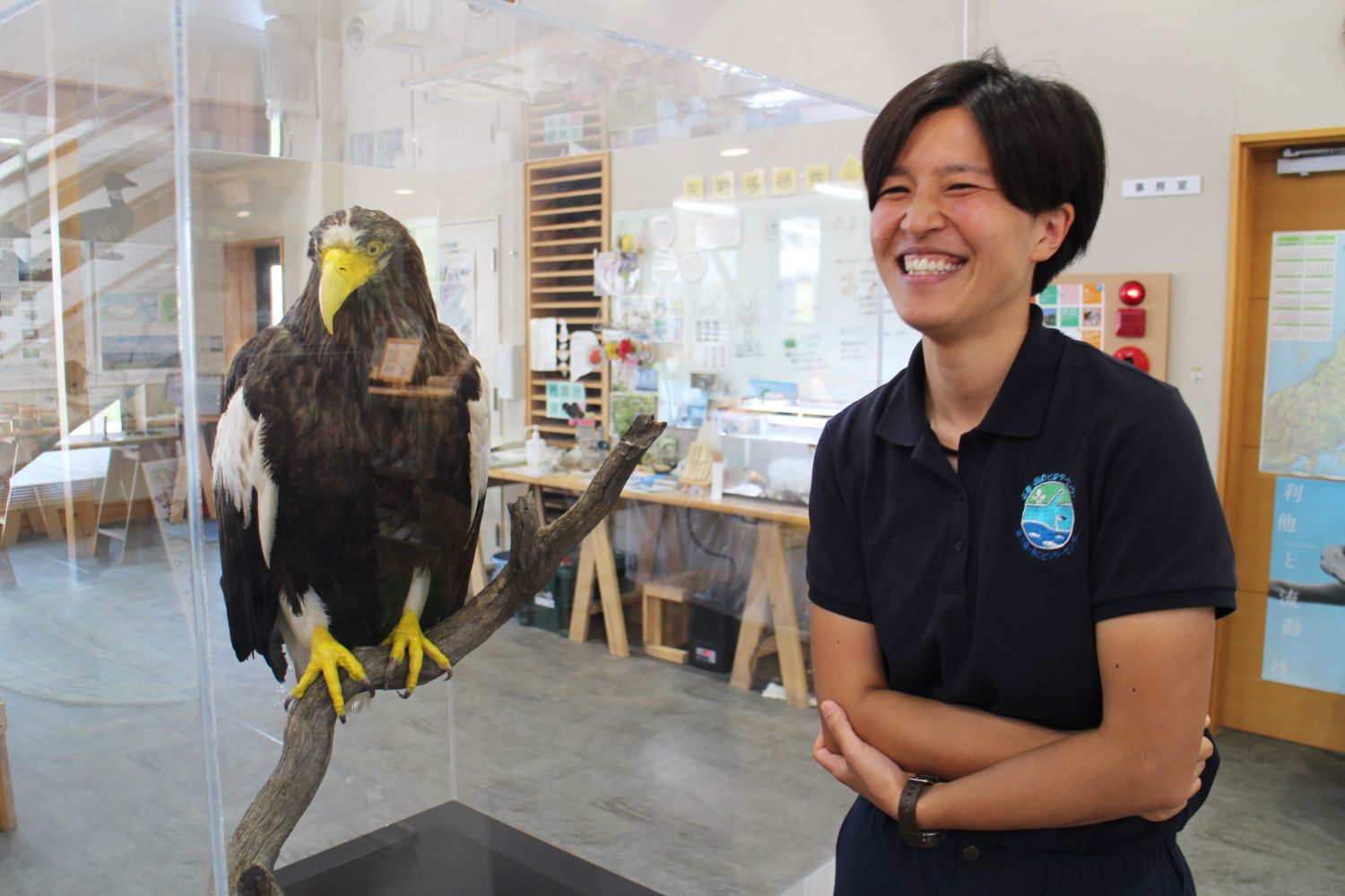 北島さんがガラスケースに展示された大きな剥製のワシを見て笑顔になっている様子の写真