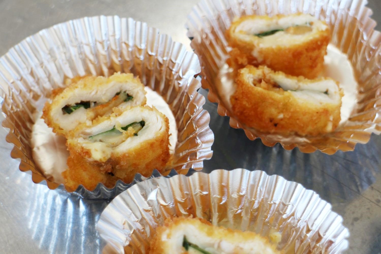 中にチーズやホヤが入ったささみフライがにカットされ、アルミカップに盛り付けられた写真